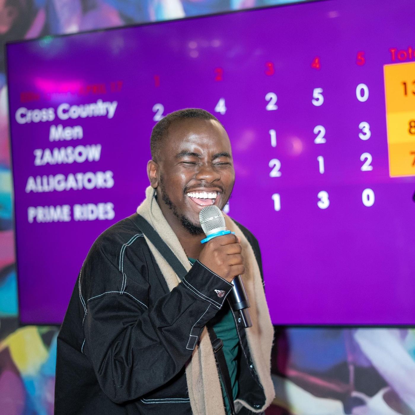 A host speaking into a microphone at an AKZAM event
