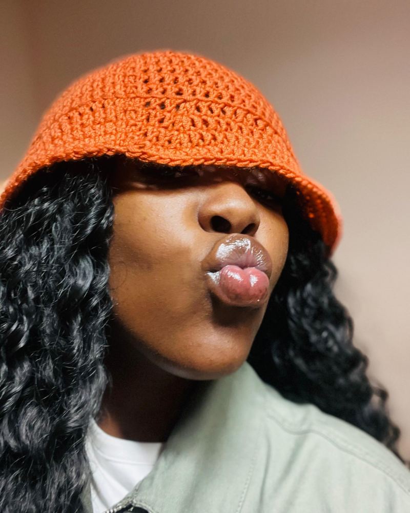 Mazuba, singer, wearing an orange bucket hat